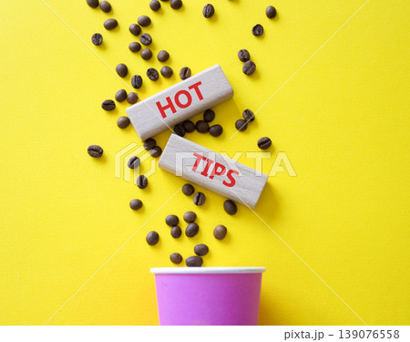 Hot Tips symbol. Concept word Hot Tips on wooden blocks. Beautiful yellow background with coffee cup. Business and Hot Tips concept. Copy space Hot Tips symbol. Concept word Hot Tips on wooden blocks. Beautiful yellow background with coffee cup. Business and Hot Tips concept. Copy space 139076558