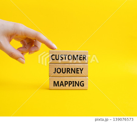 Customer Journey Mapping symbol. Concept word Customer Journey Mapping on wooden blocks. Businessman hand. Beautiful yellow background. Business and Customer Journey Mapping. Copy space 139076573