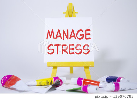 Manage stress symbol. Concept word Manage stress on wooden blocks. Beautiful white background with paints and easel. Business and Manage stress concept. Copy space 139076793