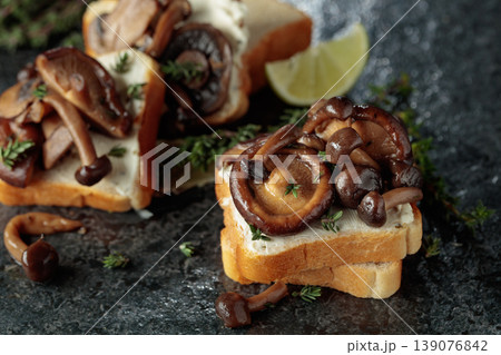 Sandwiches with cream cheese, shiitake and shimeji mushrooms, lime wedges and sprigs of thyme. Sandwiches with cream cheese, shiitake and shimeji mushrooms, lime wedges and sprigs of thyme. 139076842