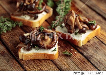 Sandwiches with baked mushrooms on an old wooden table. Sandwiches with baked mushrooms on an old wooden table. 139076844