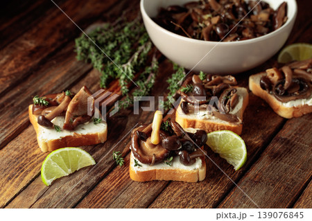Sandwiches with baked mushrooms on an old wooden table. Sandwiches with baked mushrooms on an old wooden table. 139076845