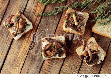 Sandwiches with baked mushrooms on an old wooden table. Sandwiches with baked mushrooms on an old wooden table. 139076846