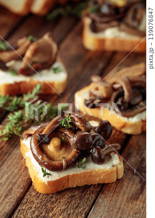 Sandwiches with baked mushrooms on an old wooden table. Sandwiches with baked mushrooms on an old wooden table. 139076847