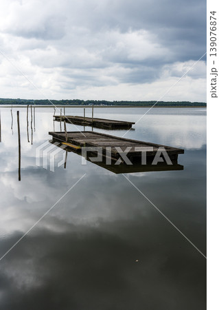Lake of Soustons reflecting a cloudy sky and wooden docks 139076874