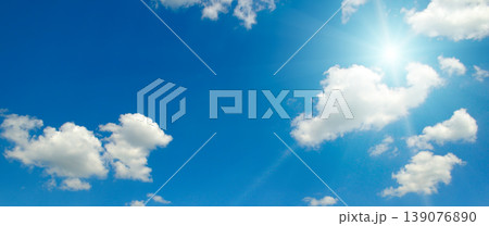 Clear blue sky with white fluffy clouds and bright radiant sun. Clear blue sky with white fluffy clouds and bright radiant sun. 139076890