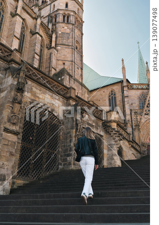 Woman Walking Up Cathedral Stairs in Historic European City 139077498