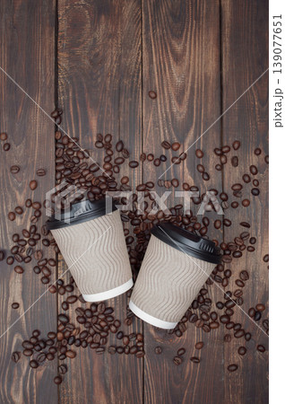dark plank background, hot take-away coffee on a wooden table, coffee beans . top view, copyspace. dark plank background, hot take-away coffee on a wooden table, coffee beans . top view, copyspace. 139077651