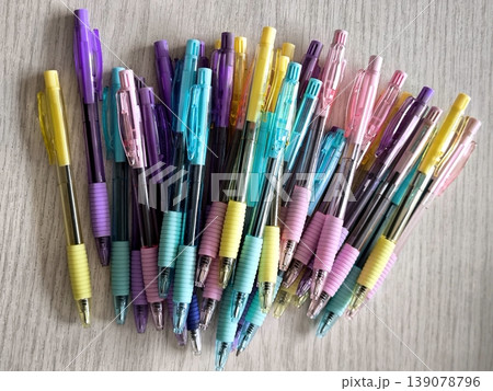 A large group of multi-colored automatic pens on a light background 139078796