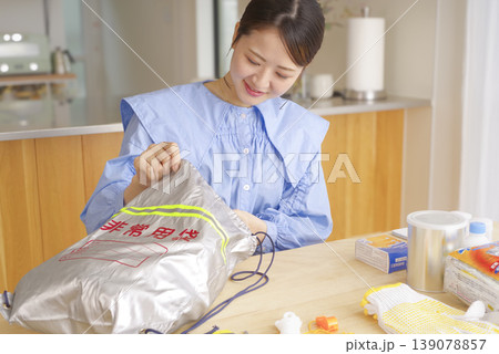 非常持ち出し袋の中身を確認する女性 139078857