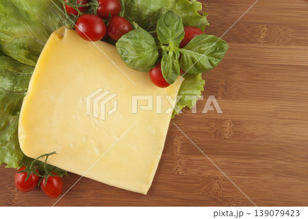 Cheese Tomato and Greens on Wood Background Cheese Tomato and Greens on Wood Background 139079423