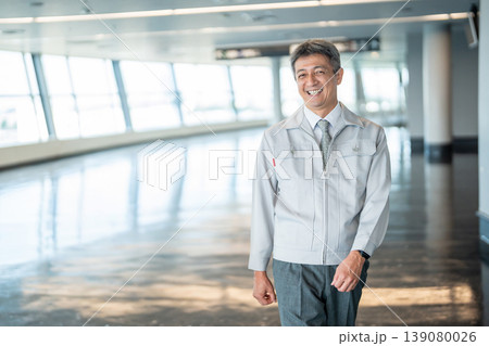 オフィスの廊下に立つ作業服の男性 オフィスの廊下に立つ作業服の男性 139080026