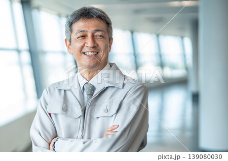 腕組みをする作業着の男性 腕組みをする作業着の男性 139080030