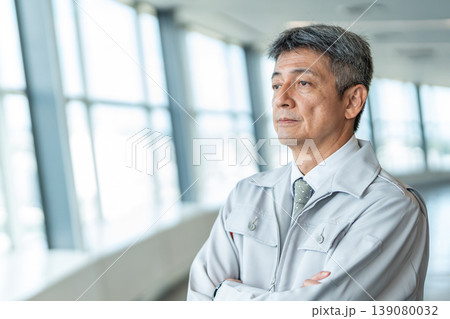 腕組みをする作業着の男性 139080032