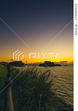 南国の遊歩道と穏やかな海が広がる夕暮れの沖縄風景 南国の遊歩道と穏やかな海が広がる夕暮れの沖縄風景 139080929