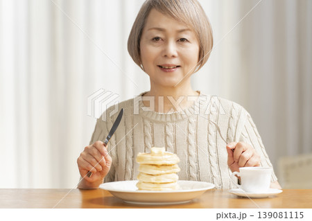 ダイニングでパンケーキを食べるシニア女性 ダイニングでパンケーキを食べるシニア女性 139081115