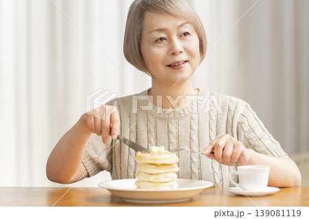 ダイニングでパンケーキを食べるシニア女性 ダイニングでパンケーキを食べるシニア女性 139081119