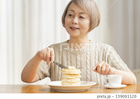 ダイニングでパンケーキを食べるシニア女性 ダイニングでパンケーキを食べるシニア女性 139081120