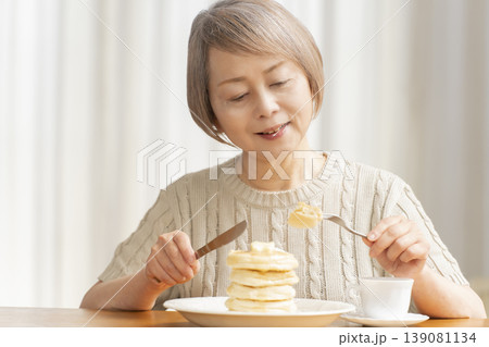 ダイニングでパンケーキを食べるシニア女性 ダイニングでパンケーキを食べるシニア女性 139081134