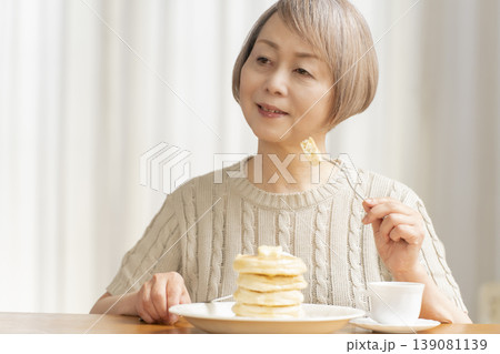 ダイニングでパンケーキを食べるシニア女性　 139081139