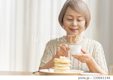 ダイニングでパンケーキを食べるシニア女性 ダイニングでパンケーキを食べるシニア女性 139081140
