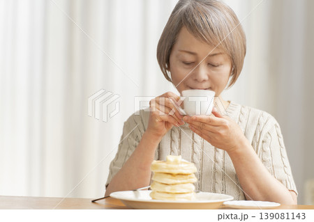 ダイニングでパンケーキを食べるシニア女性 ダイニングでパンケーキを食べるシニア女性 139081143