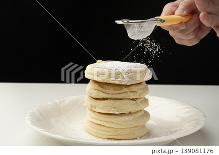 焼きあがったリコッタチーズのパンケーキを皿に盛り付ける 139081176