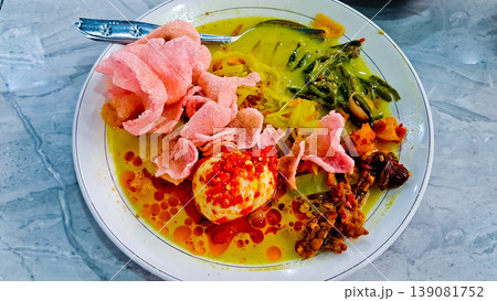 close-up photo of delicious traditional Indonesian food, lontong sayur with egg, potato, stir-fried tempeh and crackers toppings close-up photo of delicious traditional Indonesian food, lontong sayur with egg, potato, stir-fried tempeh and crackers toppings 139081752