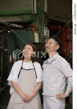 製造業などの町工場で働く夫婦の笑顔で未来や希望を見つめる(見上げる)　中小企業の家族経営とものづくり 139082461