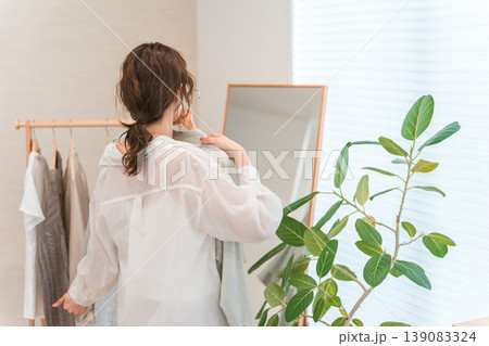 姿見の鏡を見ながら洋服を選ぶアジア人女性（ショッピング,コーディネート,セール,買い物） 139083324