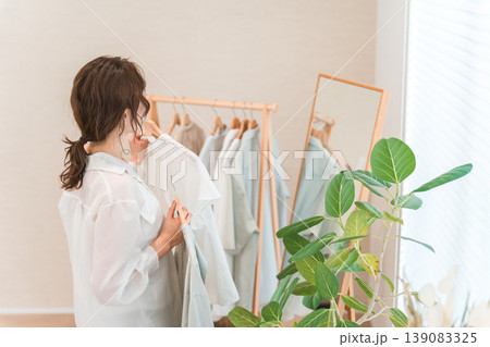 姿見の鏡を見ながら洋服を選ぶアジア人女性（ショッピング,コーディネート,セール,買い物） 139083325
