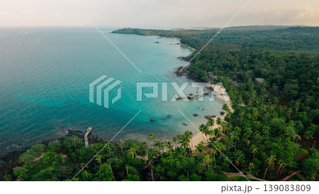 Aerial view of a beautiful tropical island coastline with clear turquoise water, white sand beach, and lush green palm trees. Aerial view of a beautiful tropical island coastline with clear turquoise water, white sand beach, and lush green palm trees. 139083809
