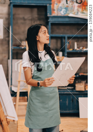Female artist wears black hat posing near picture indoor the studio Female artist wears black hat posing near picture indoor the studio 139084223
