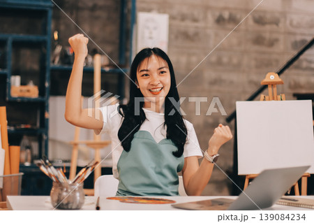 Female artist wears black hat posing near picture indoor the studio 139084234