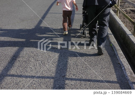 夕方の帰り道を歩く親子とベビーカーの影 夕方の帰り道を歩く親子とベビーカーの影 139084669