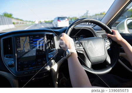 車を運転する女性の手元 139085073