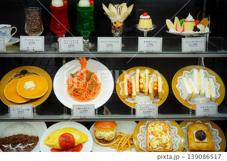 レストラン店頭に並ぶ多彩なメニューの食品サンプル、カラフルな日本の昭和スタイルの喫茶店・洋食メニュー 139086517