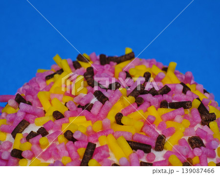 Delicious cupcake with colorful sugar coating on blue background Delicious cupcake with colorful sugar coating on blue background 139087466