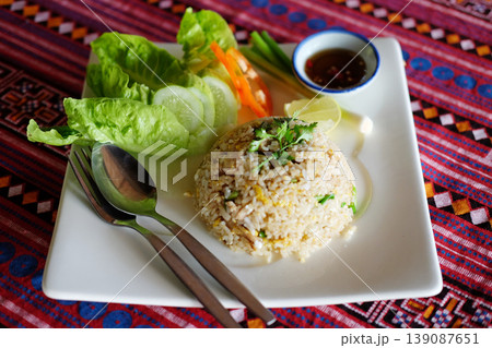 Fried rice with Thai cuisine on white plate on wooden table from top view Fried rice with Thai cuisine on white plate on wooden table from top view 139087651