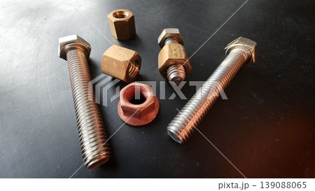 Assorted metal bolts and nuts on a dark surface showing different sizes and shapes Assorted metal bolts and nuts on a dark surface showing different sizes and shapes 139088065