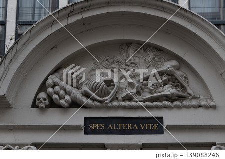 Architectural stone relief with carved figures and Latin inscription on historic building facade detail Architectural stone relief with carved figures and Latin inscription on historic building facade detail 139088246