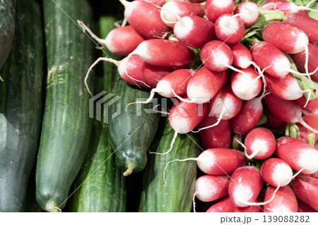 Close up fresh cucumbers and red radishes stacked together showing vibrant healthy organic vegetables 139088282