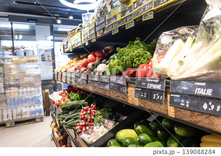 Grocery store produce section with fresh vegetables arranged on shelves in modern supermarket interior Grocery store produce section with fresh vegetables arranged on shelves in modern supermarket interior 139088284