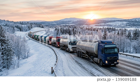 Long line of trucks driving on a snowy road in a mountainous area at sunset during winter season 139089188