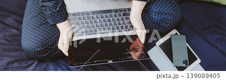 top view asian woman in classic blue pajama cloth work from home with serious feeling and sit on her bed for protect corona or covid-19 virus 139089405
