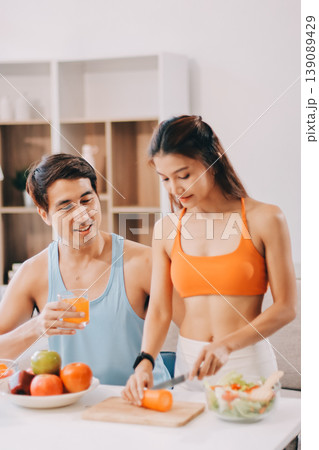 A happy couple prepares fresh vegetables, laughing and enjoying cooking a healthy meal together. A happy couple prepares fresh vegetables, laughing and enjoying cooking a healthy meal together. 139089429