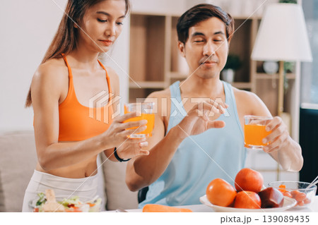 A happy couple prepares fresh vegetables, laughing and enjoying cooking a healthy meal together. A happy couple prepares fresh vegetables, laughing and enjoying cooking a healthy meal together. 139089435