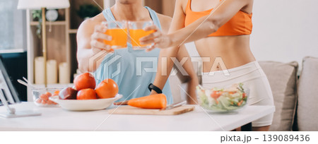 A happy couple prepares fresh vegetables, laughing and enjoying cooking a healthy meal together. A happy couple prepares fresh vegetables, laughing and enjoying cooking a healthy meal together. 139089436