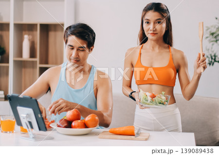 A happy couple prepares fresh vegetables, laughing and enjoying cooking a healthy meal together. A happy couple prepares fresh vegetables, laughing and enjoying cooking a healthy meal together. 139089438