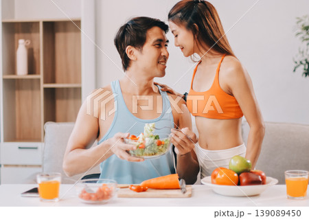 A happy couple prepares fresh vegetables, laughing and enjoying cooking a healthy meal together. A happy couple prepares fresh vegetables, laughing and enjoying cooking a healthy meal together. 139089450
